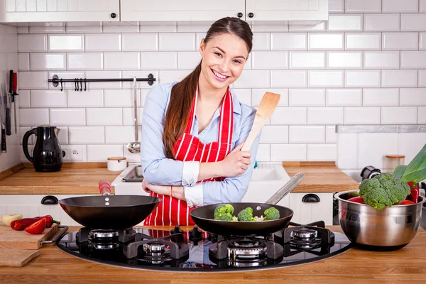 Ung kvinna matlagning i köket. Royaltyfria Stockbilder