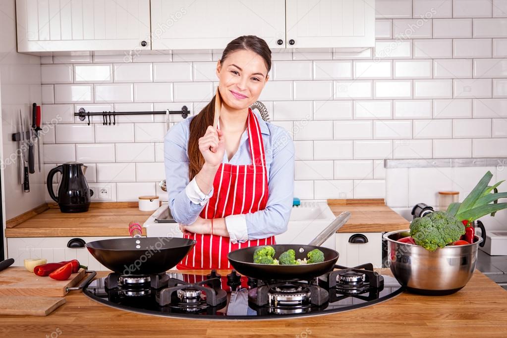 Young woman cooking in kitchen.