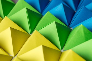 Fütüristik arka plan mavi, yeşil ve sarı origami piramitleri