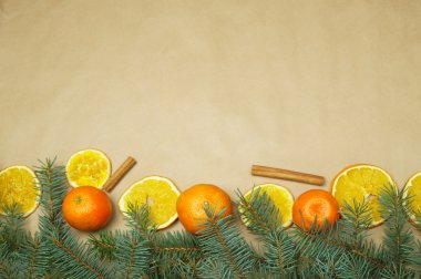 Çam dalları, mandarin ve portakal dilimleri Kraft kağıt üzerinde Noel kompozisyonu