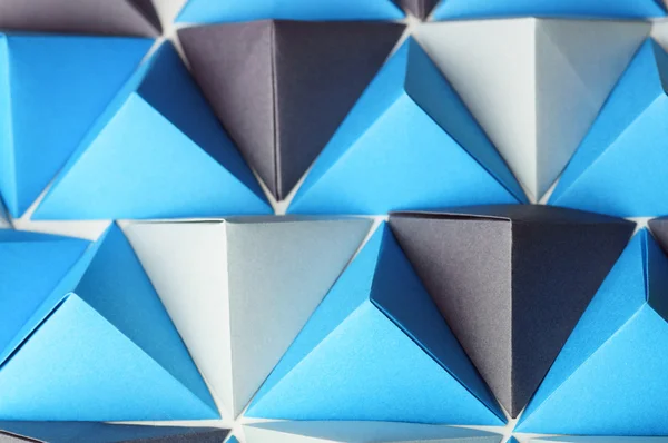 Fondo abstracto con tetraedros de origami negro, azul y gris — Foto de Stock