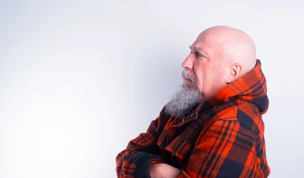 頭を剃った赤い布のジャケットの中に灰色の髭を生やした 不満を持った 警戒心のある中年の男 — ストック写真