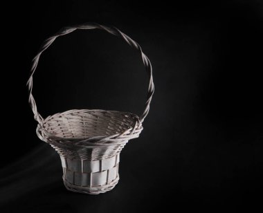 Karanlık bir arka planda hasır sepet.