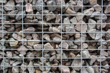 Metal ağ kılıfı, bahçe çiti ve dekorasyonu olan taş duvar.