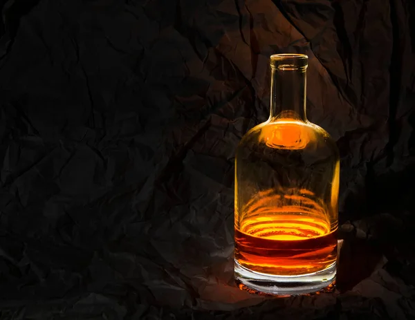 dark brown liquid bottle with refraction and highlights on dark background