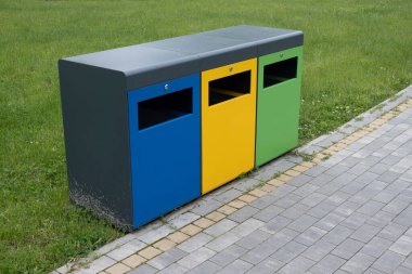 Yolun yakınındaki çimenlikte çöp kutularını ayıkla