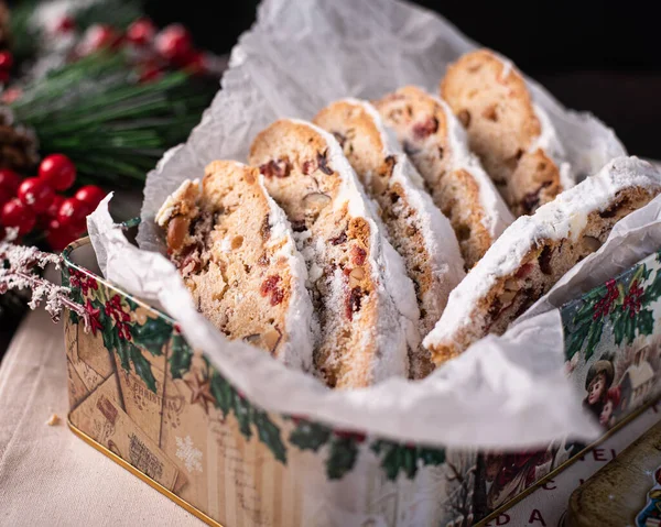 Traditional Stollen raisin cake for Christmas treats with nuts, spices and dried fruits. Traditional Christmas festive pastry dessert. Christmas stollen in a box. Christmas pastries in a gift box.