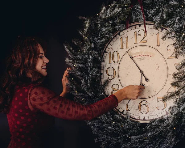 New Years party. a young woman looks at the clock in anticipation of midnight December.