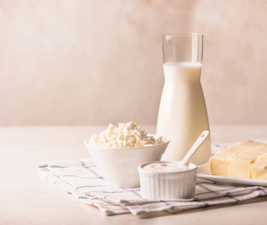 Süt, süzme peynir, ekşi krema, tereyağı, arka planda yumurta. Süt besinleri