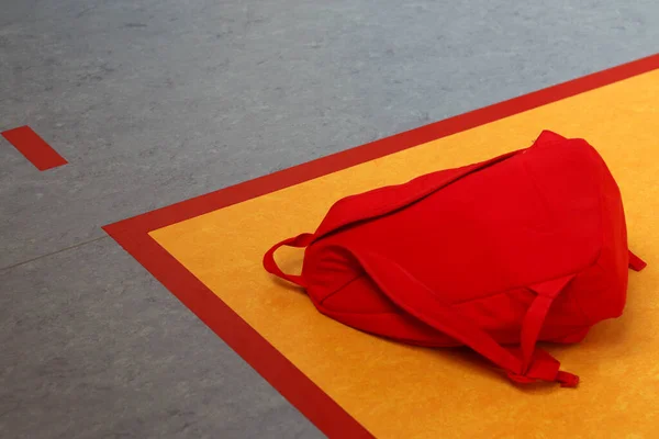 kırmızı sırt çantası ve yerde renkli çanta.