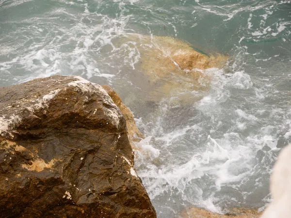 Kayalar, dalgalar ve su damlalarıyla güzel deniz manzarası