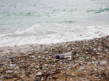 Sahildeki çöpler. Deniz manzarası. Dalgalar ve köpüklerle kayalıklarda dalgalanan deniz dalgaları..