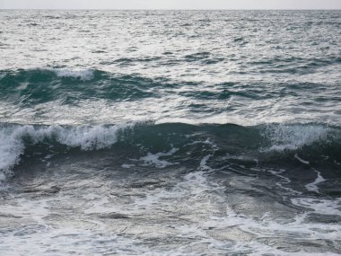 Deniz kıyısındaki dalgalar ve köpükler kayalıklarda dalgalar ve köpüklerle dalgalanır..