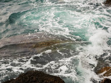 Dalgalar kayalara çarpıyor.