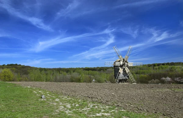 Landschap met een molen in een geploegd veld. — Stockfoto