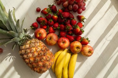 Gölgesi, ananası, muzu, elması, çileği, üzümü ve muzu olan lezzetli taze meyveler çiğ, sağlıklı yaşam tarzı, stüdyo