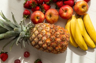 Lezzetli taze meyveler güneş, ananas, elma, çilek, üzüm ve muz, sağlıklı yaşam tarzı.