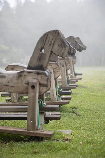 close-up on the details of the landscape of a park with games, wooden horses lined with mist, objects and nature