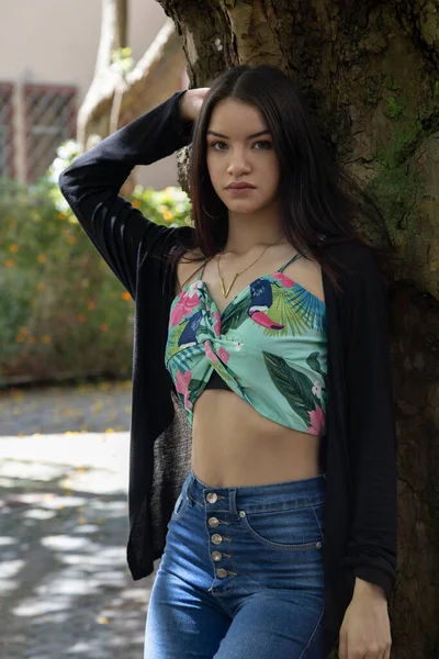 Mladá Modelka Dlouhými Vlasy Pózuje Stojící Stromu Městě Nosí Džíny — Stock fotografie