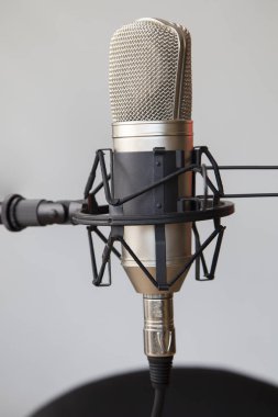closeup to a professional microphone with a stand and cable, musical instrument in studio, modern object