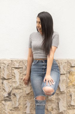 İnce yapılı, düz saçlı, kot ve modern bir tişört giyen, taş, yaşam tarzı ve modaya uygun bir kadın.