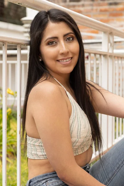 Attractive Young Woman Her Long Black Hair Sitting Leaning Railing — Stock Photo, Image