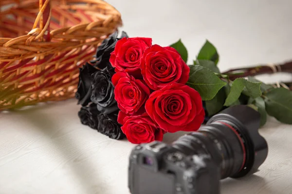 Букет Черными Красными Розами Рядом Современной Профессиональной Фотокамерой Корзиной Красивое — стоковое фото