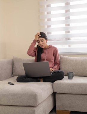 Hüsrana uğramış bir kadın evde çalışırken bilgisayarına bağırıyor. Uzak iş hayatında stres, tükenmişlik ve duygusal hüsranı temsil eder..