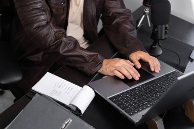 Önünde bir mikrofon bulunan bir iş adamı, çevrimiçi toplantıları, içerik oluşturmayı, uzaktan çalışmayı ve profesyonel dijital iletişimi temsil ediyor..