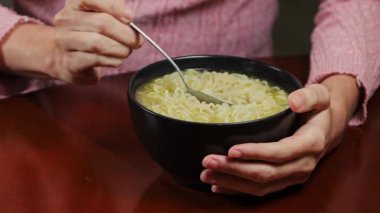 Ramen şehriyelerinin kaşıkla yenmesini, konforlu yiyeceklerin altını çizilmesini, günlük yaşam tarzını ve ev yemeklerinin rahat olmasını yakından izleyin..