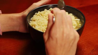 Masadaki siyah kasede erişte çorbası sıcak yemekleri, Asya mutfağını ve ev yapımı basit yemekleri simgeliyor..