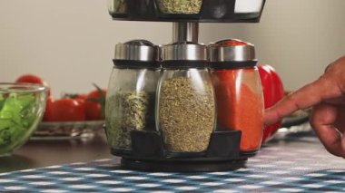 Baharat rafını çevirerek bir çeşni aramak ve yemek hazırlığını ve mutfak düzenini göstermek için arzulanan kişiyi seçmek için ellerinizi kapatın..