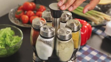 Baharat rafını döndüren, çeşni seçen, yemek hazırlama, malzeme seçimi ve düzenli mutfak rutinini temsil eden ellerinizi kapatın..