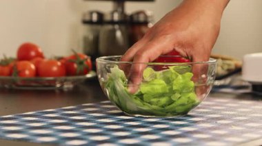 Yıkanmış marulu sudan kaldırırken ellerinizi kapatın ve sebze temizleme sürecini, tazeliği ve sağlıklı mutfak hazırlama rutinini göstererek suyu boşaltmasına izin verin..