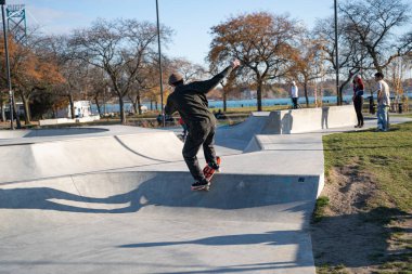 8 Kasım 2020 'de Detroit, Michigan' daki salgın sırasında patenciler ve motosikletçiler açık hava kaykay parkında numara yapıyorlar.