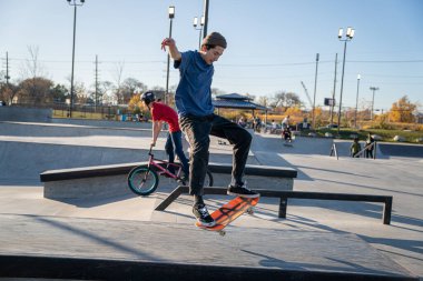 8 Kasım 2020 'de Detroit, Michigan' daki salgın sırasında patenciler ve motosikletçiler açık hava kaykay parkında numara yapıyorlar.