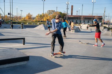 8 Kasım 2020 'de Detroit, Michigan' daki salgın sırasında patenciler ve motosikletçiler açık hava kaykay parkında numara yapıyorlar.