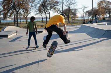 8 Kasım 2020 'de Detroit, Michigan' daki salgın sırasında patenciler ve motosikletçiler açık hava kaykay parkında numara yapıyorlar.