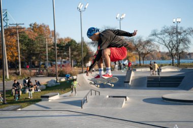 8 Kasım 2020 'de Detroit, Michigan' daki salgın sırasında patenciler ve motosikletçiler açık hava kaykay parkında numara yapıyorlar.