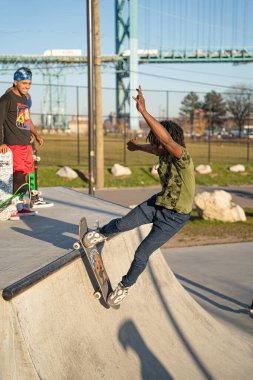 8 Kasım 2020 'de Detroit, Michigan' daki salgın sırasında patenciler ve motosikletçiler açık hava kaykay parkında numara yapıyorlar.
