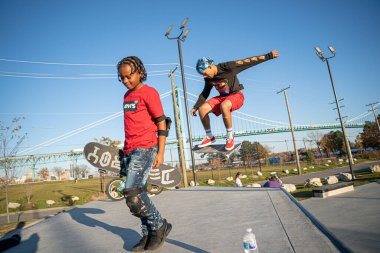 8 Kasım 2020 'de Detroit, Michigan' daki salgın sırasında patenciler ve motosikletçiler açık hava kaykay parkında numara yapıyorlar.
