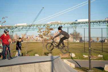 8 Kasım 2020 'de Detroit, Michigan' daki salgın sırasında patenciler ve motosikletçiler açık hava kaykay parkında numara yapıyorlar.