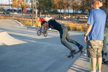 8 Kasım 2020 'de Detroit, Michigan' daki salgın sırasında patenciler ve motosikletçiler açık hava kaykay parkında numara yapıyorlar.