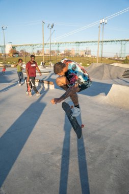 8 Kasım 2020 'de Detroit, Michigan' daki salgın sırasında patenciler ve motosikletçiler açık hava kaykay parkında numara yapıyorlar.