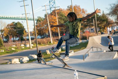 8 Kasım 2020 'de Detroit, Michigan' daki salgın sırasında patenciler ve motosikletçiler açık hava kaykay parkında numara yapıyorlar.
