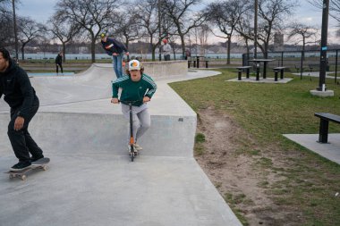 Patenciler ve motorcular 19 Kasım 2020 'de Detroit, Michigan / ABD' de bir açık hava kaykay parkında numara yapıyorlar.