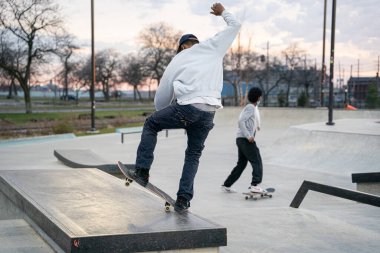 Patenciler ve motorcular 19 Kasım 2020 'de Detroit, Michigan / ABD' de bir açık hava kaykay parkında numara yapıyorlar.