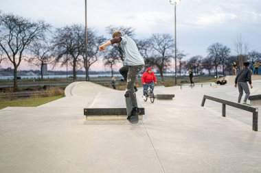 Patenciler ve motorcular 19 Kasım 2020 'de Detroit, Michigan / ABD' de bir açık hava kaykay parkında numara yapıyorlar.