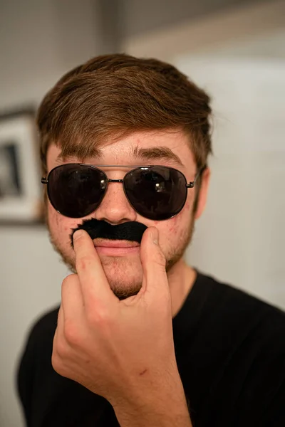 Ung Man Solglasögon Sätter Sig Falsk Mustasch Förklädnad — Stockfoto