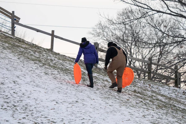 在底特律的一个公园里 朋友和家人正沿着一座大山滑下 — 图库照片